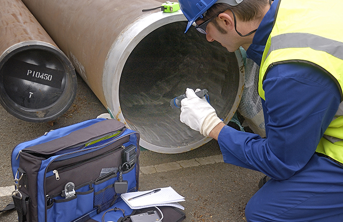 Person inspecting the inside of a pipe for defects